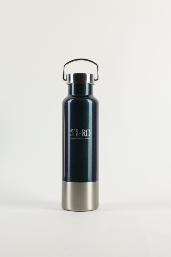 A dark teal insulated water bottle with a stainless steel base and a black carrying loop, featuring the brand name 'SHORD' printed on the front, set against a plain light gray background.