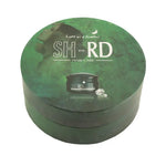 A round green cardboard gift box for SH-RD Hair Care, featuring a printed graphic of a woman with long light brown hair and a small jar of hair product on the lid, set against a plain white background.