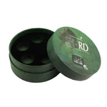A round dark green cosmetic box shown open with the lid leaning against the base. The lid has white text reading 'SH-RD' and 'TAN CARE,' plus a small printed product photo.
