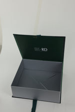An open dark green and gray presentation box with the brand name 'SH-RD' printed on the inside lid, set against a plain light background.