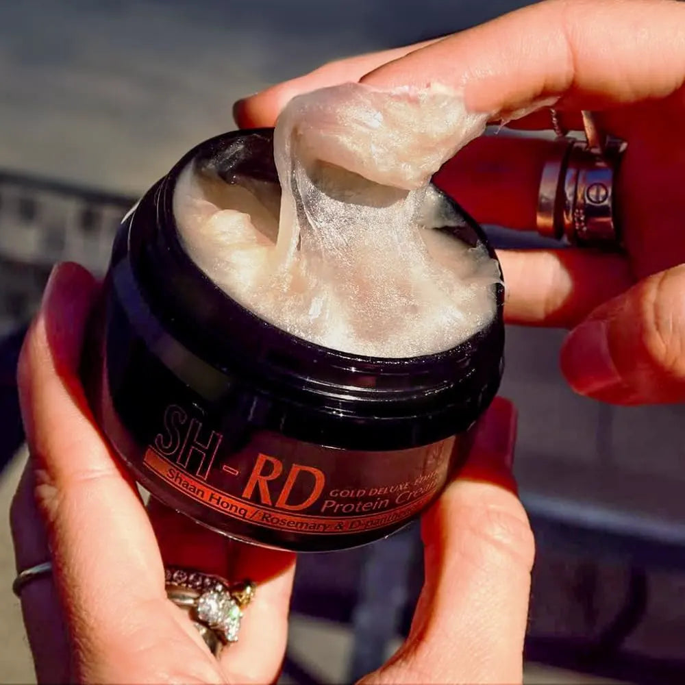 Person holding a jar of protein cream with a blurred background